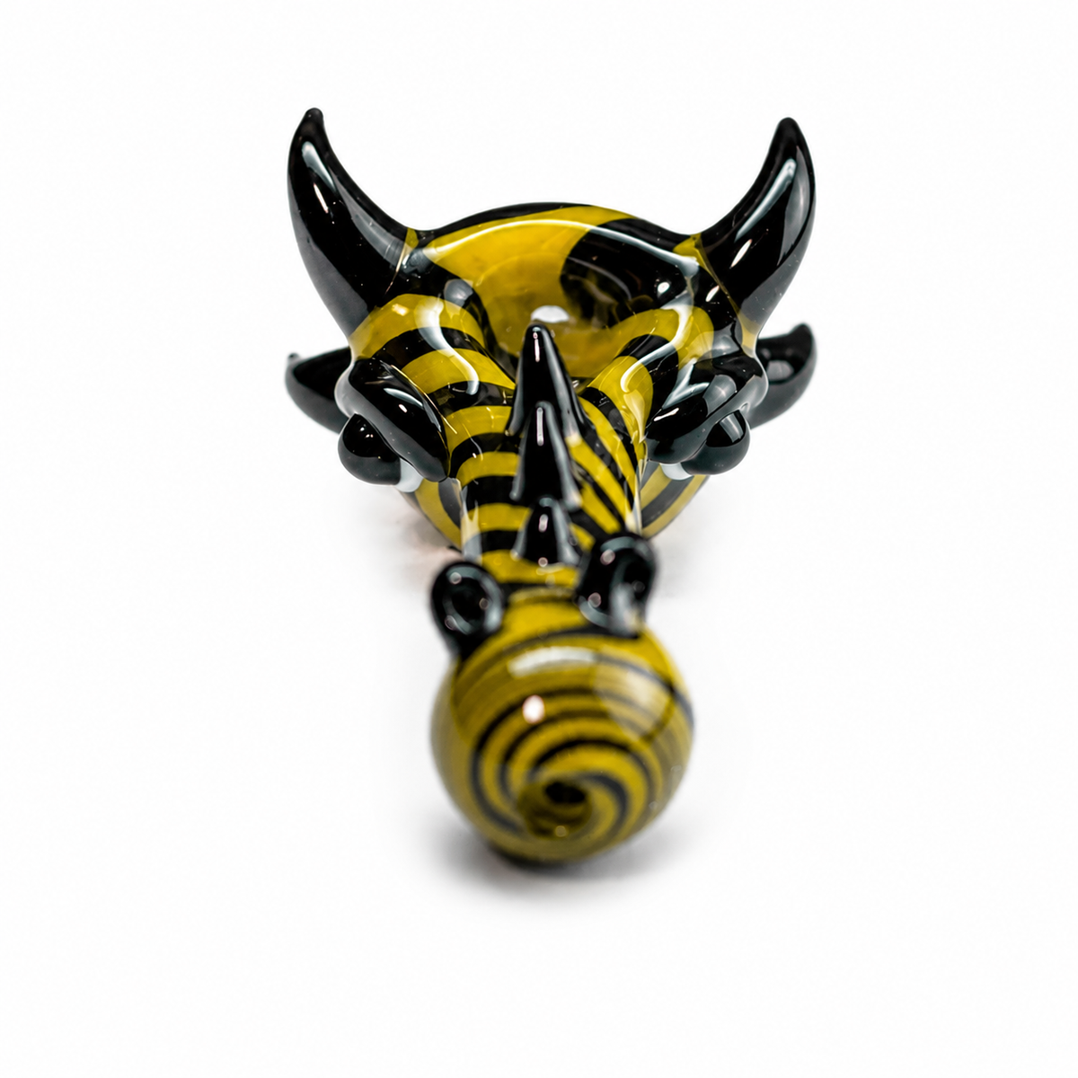 A yellow and black striped bull head figurine with glossy black horns, photographed from a top-down angle on a white background.