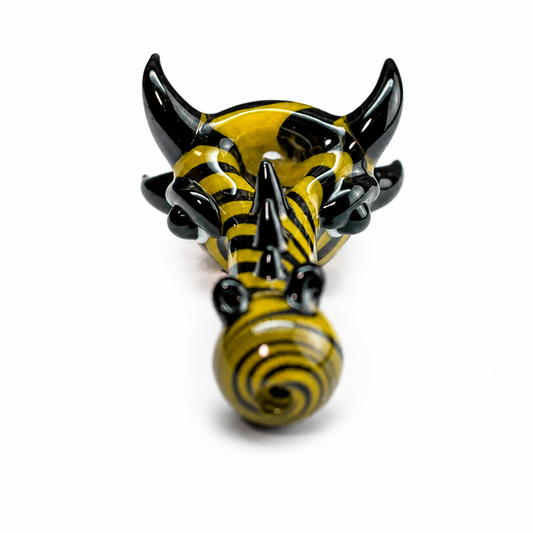 A yellow and black striped bull head figurine with glossy black horns, photographed from a top-down angle on a white background.